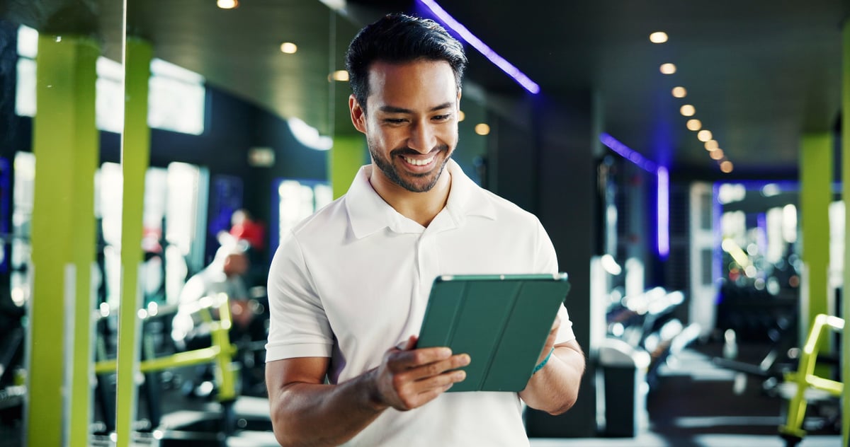 Fitness manager gebruikt tablet met ledenplatform